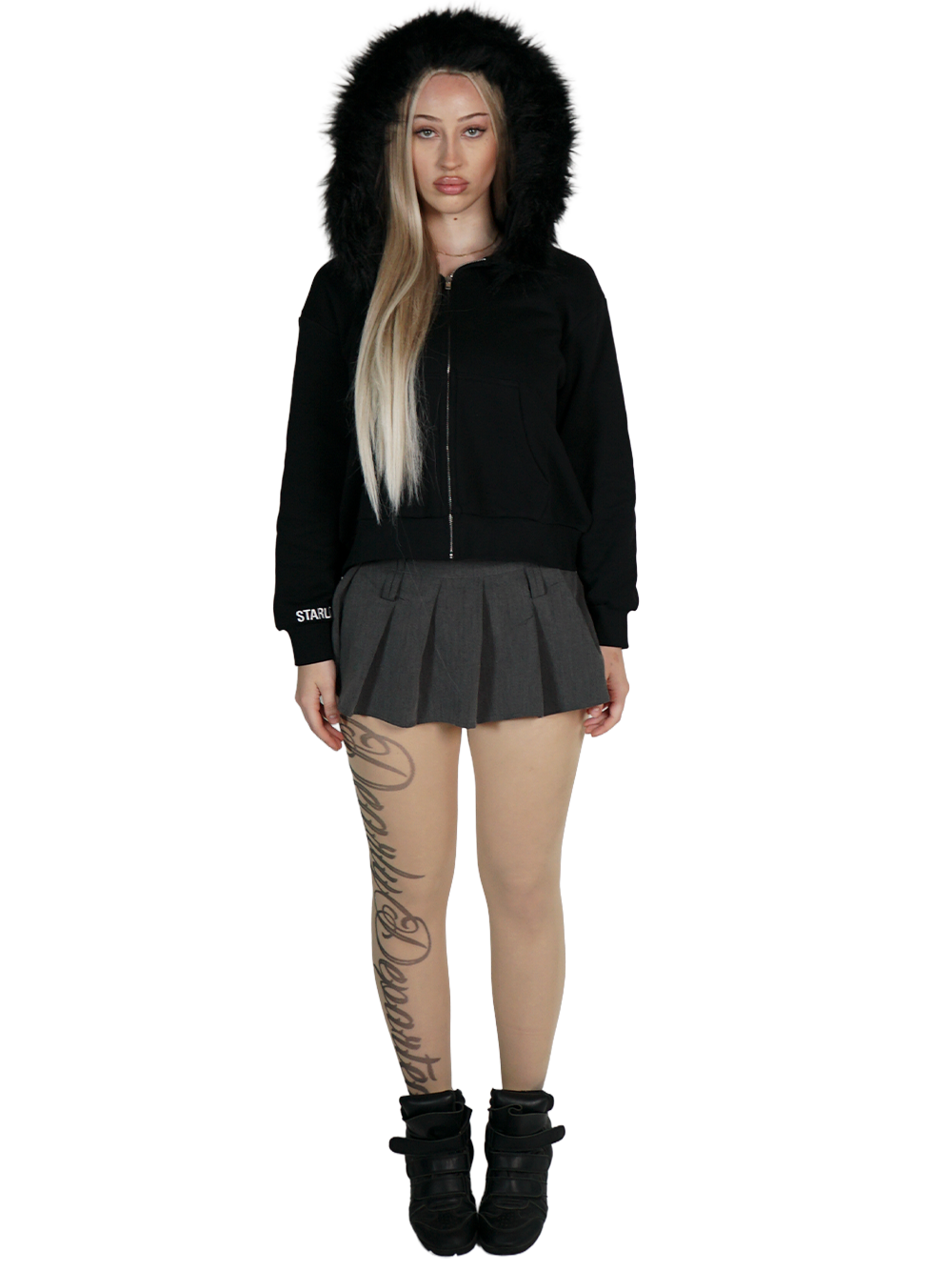 Person wearing a black hoodie with fur hood, black skirt, and black boots on a white background