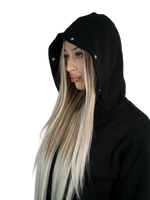 Woman wearing a black hooded garment with a plain background