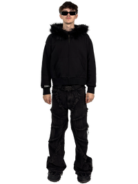 Front view of a model wearing a Starlit black fur hoodie with fur, highlighting the luxurious fur details and contemporary streetwear style.