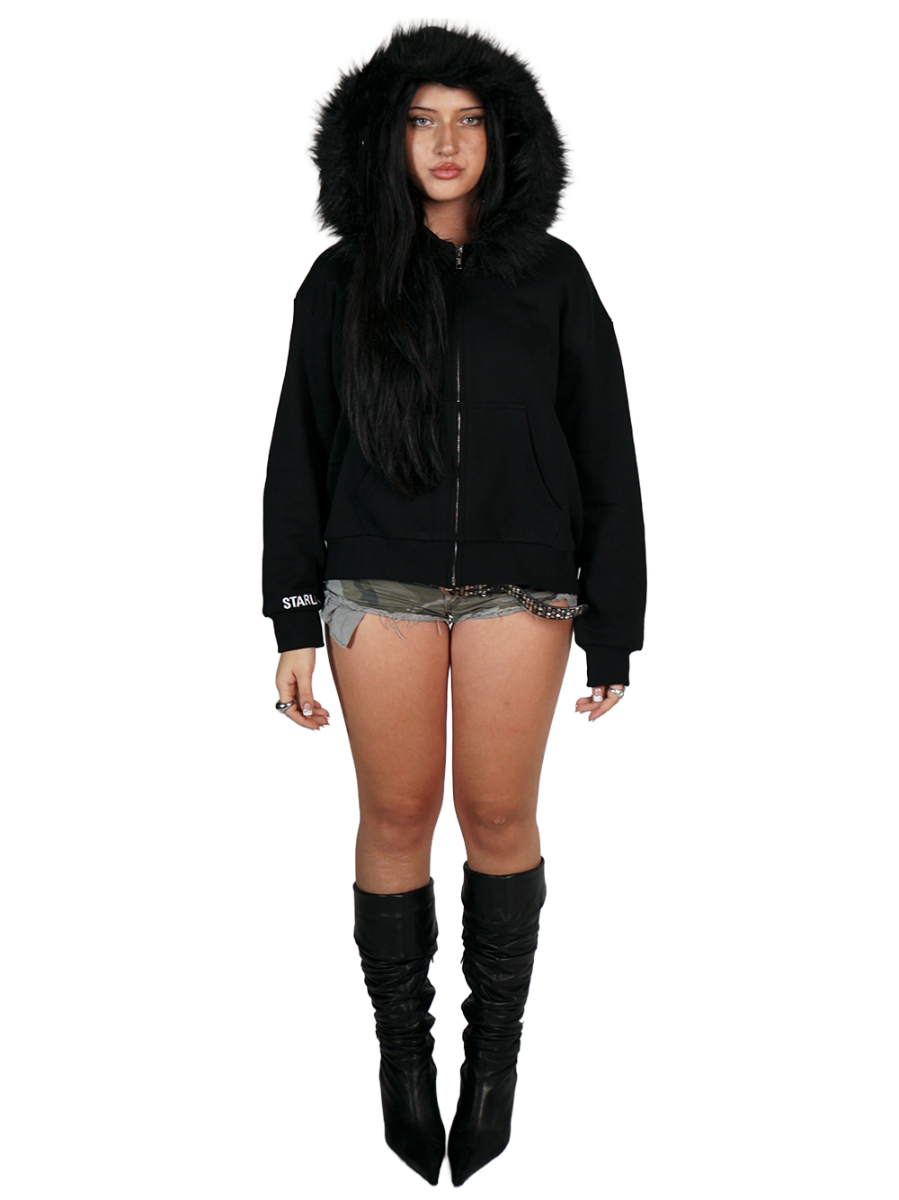 Person wearing a black hoodie with fur hood, shorts, and knee-high boots on a white background