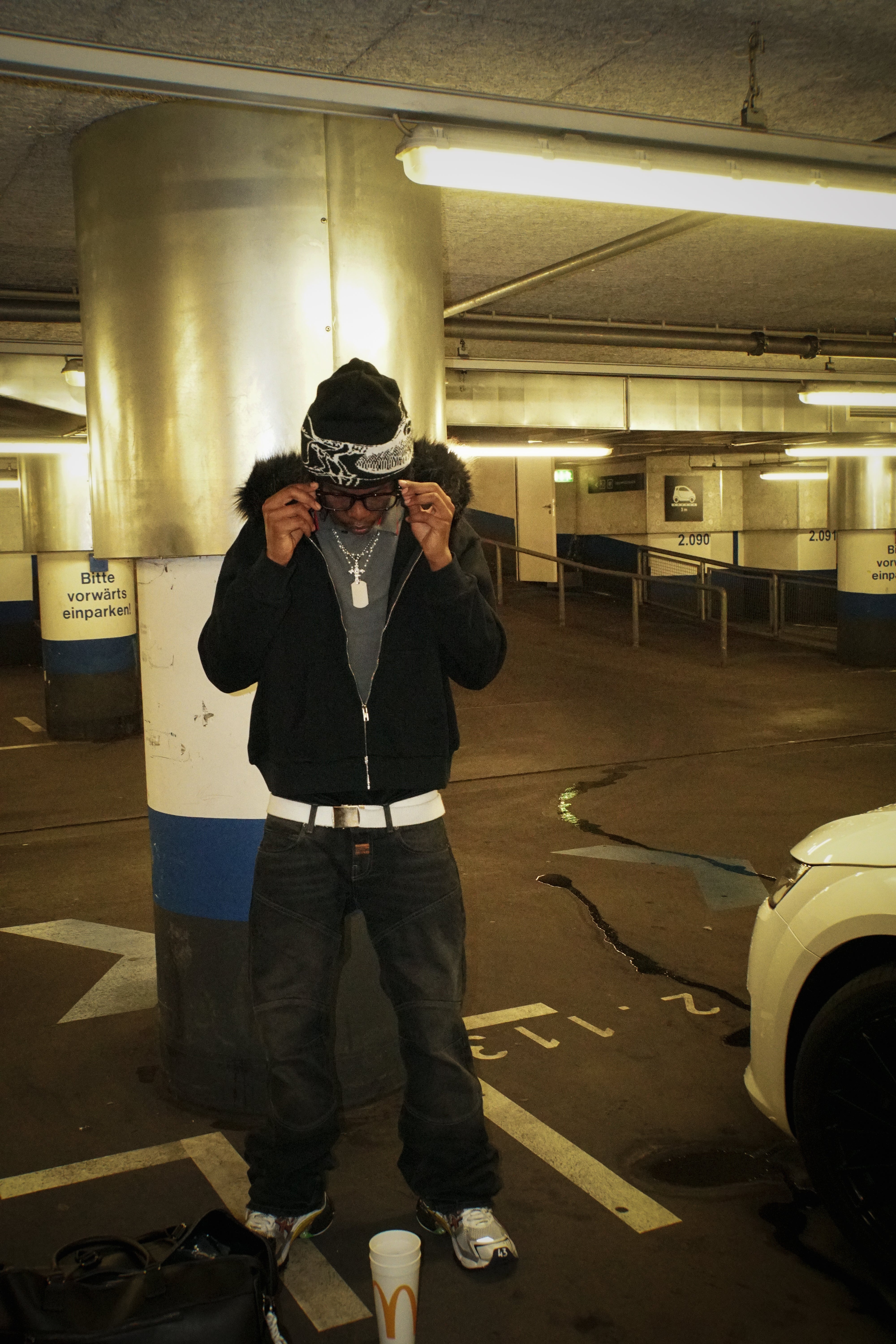 Person taking a selfie in a dimly lit parking garage