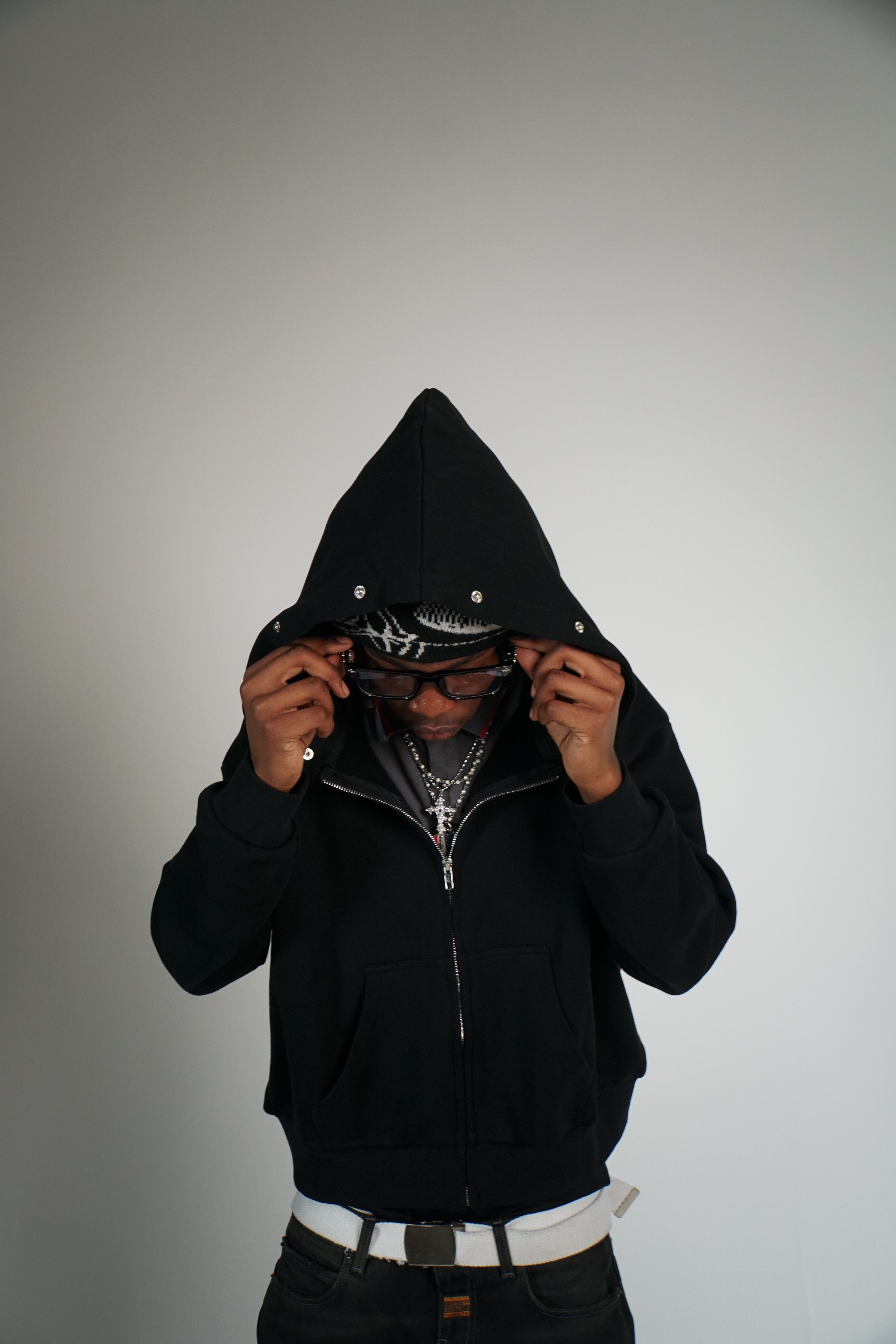 Person wearing a black hoodie with a white background