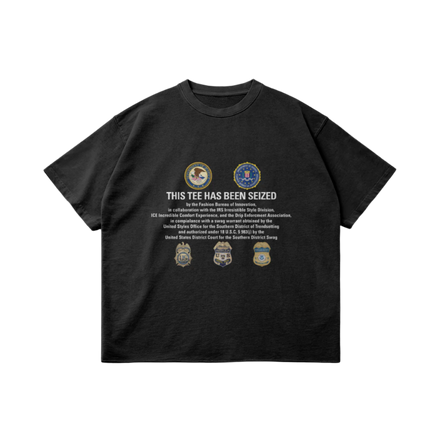 Black T-shirt with ‘This Tee Has Been Seized’ print and iconic badges, combining bold streetwear and luxury design.