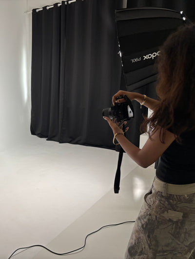 Person taking a photo with a camera in a studio setting